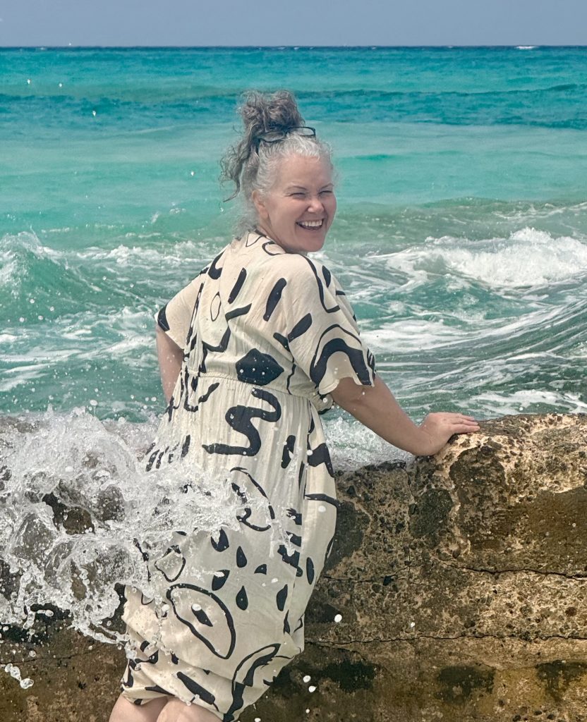 traveler on beach getting sprayed with water