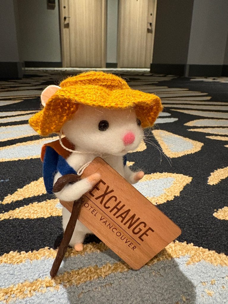 Toy mouse standing in hotel with hotel card