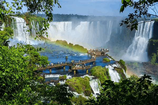 tourists amidst jungle and giant waterfall